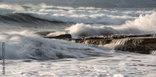 Rocky seashore with wavy ocean and waves crashing on the rocks © Michalis Palis