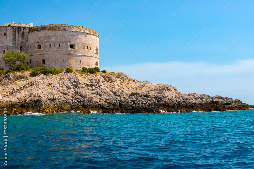 Incredible seascape. Old tower on a rocky shore by the sea, Boka-Kotor Bay, Montenegro