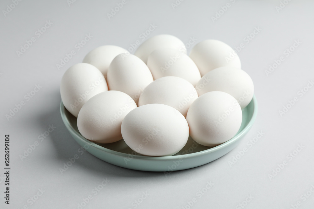 Chicken eggs in plate on gray background, space for text Chicken eggs in plate on gray background, space for text