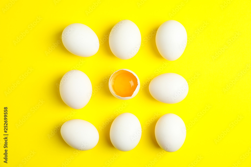 Flat lay composition with chicken eggs and half with yolk on color background, space for text Flat lay composition with chicken eggs and half with yolk on color background, space for text