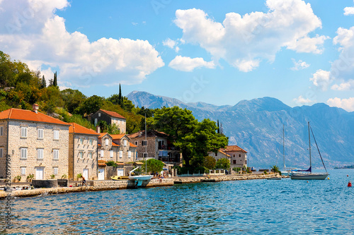 Scenic panoramic view of the historical city of Perast, located in the Bay of Kotor on a sunny day with blue sky and white clouds in summer, Montenegro, southern Europe © Natallia