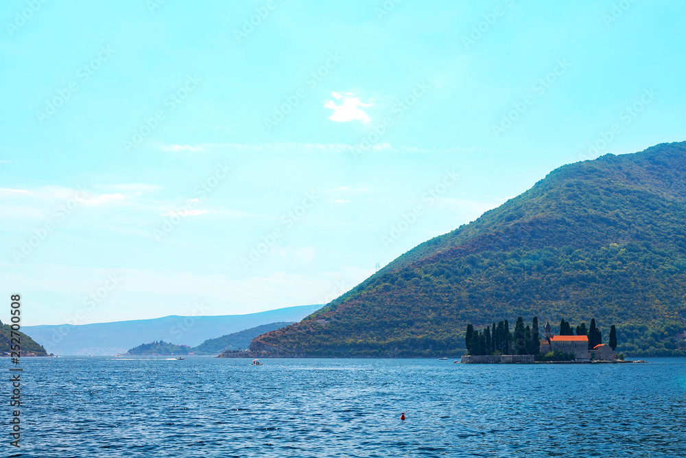 Incredible bright seascape. View of green wooded mountains and blue sea, blue sky and white clouds. Boka Kotorska Bay, Montenegro