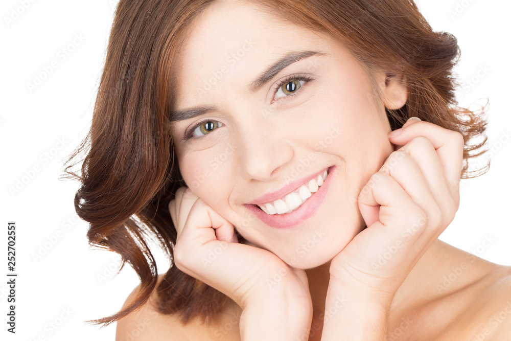 Shining from the inside. Close up portrait of a beautiful female model smiling happily touching her face Shining from the inside. Close up portrait of a beautiful female model smiling happily touching her face