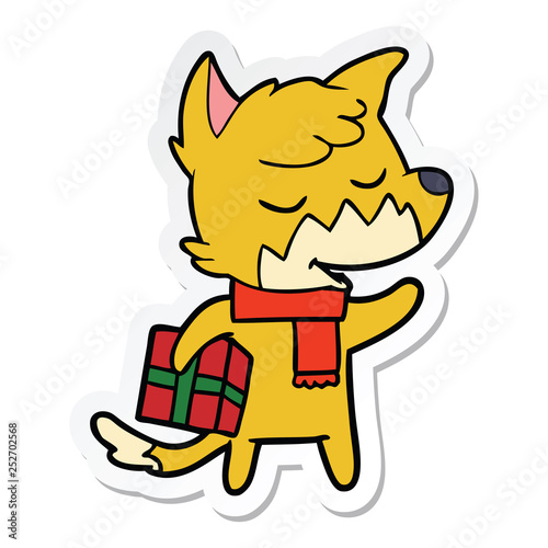 sticker of a friendly cartoon fox with christmas present