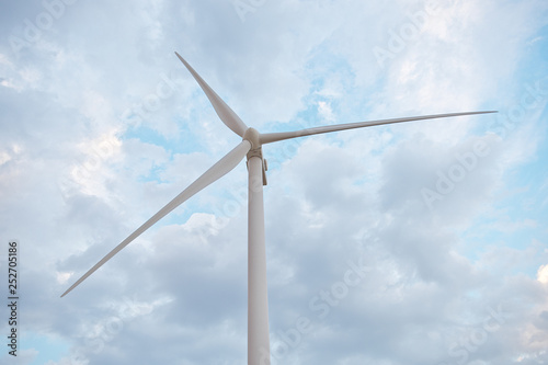 Row of wind power generators on blue sky background