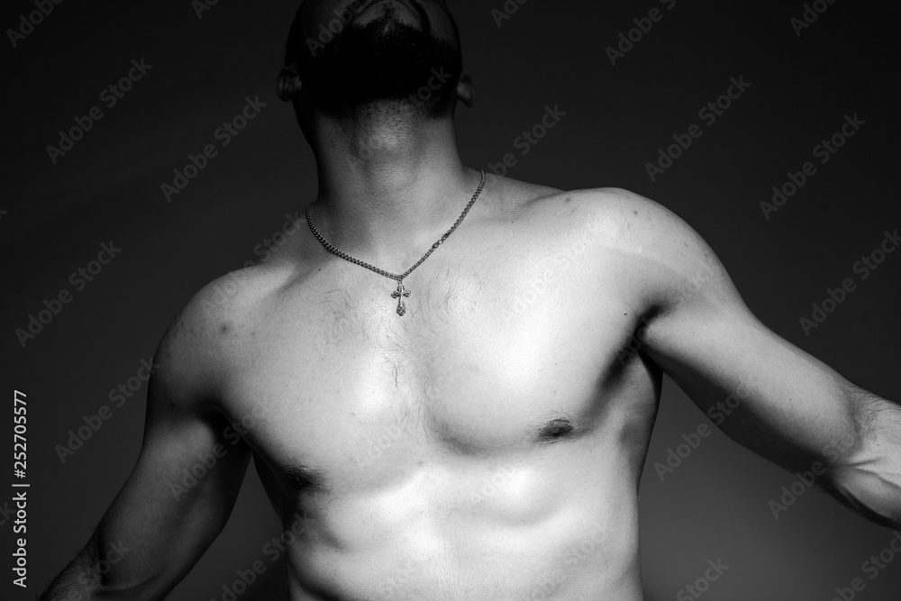Naklejka premium Black and white photo of a handsome and sporty guy close-up in studio