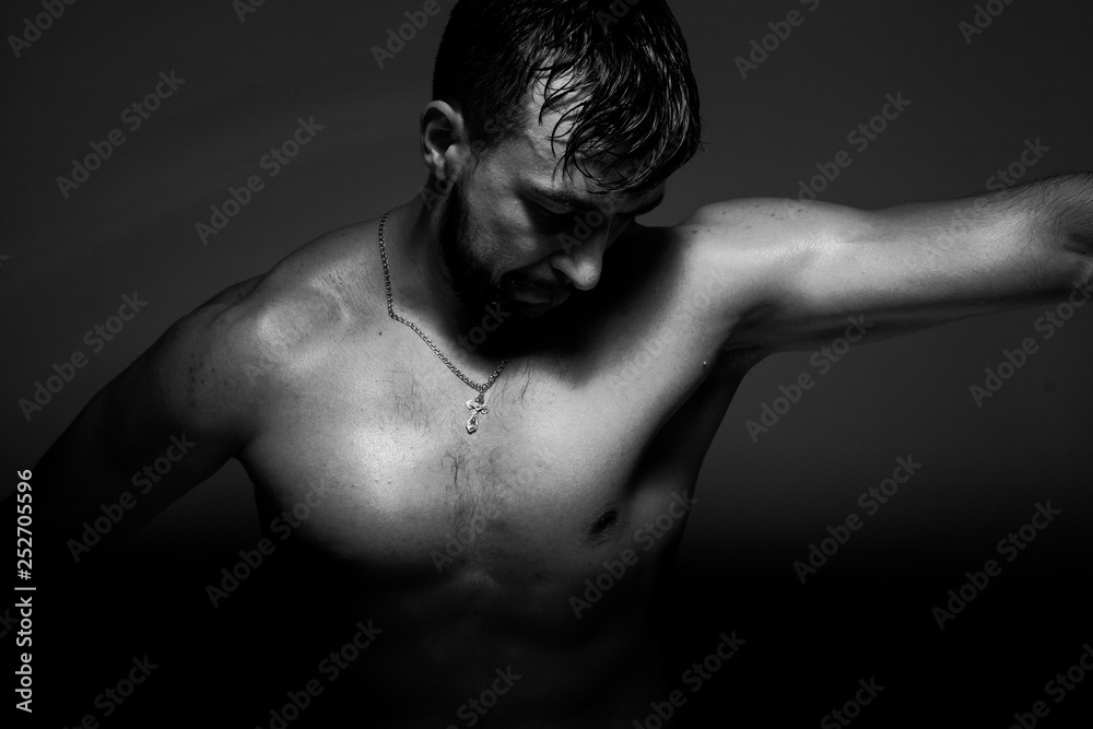 Naklejka premium Black and white photo of a handsome and sporty guy close-up in studio