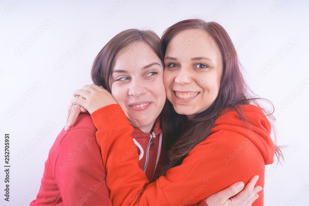 two friends or lesbians on a white background, smiling and laughing in the company of each other. The concept of female friendship and love two friends or lesbians on a white background, smiling and laughing in the company of each other. The concept of female friendship and love