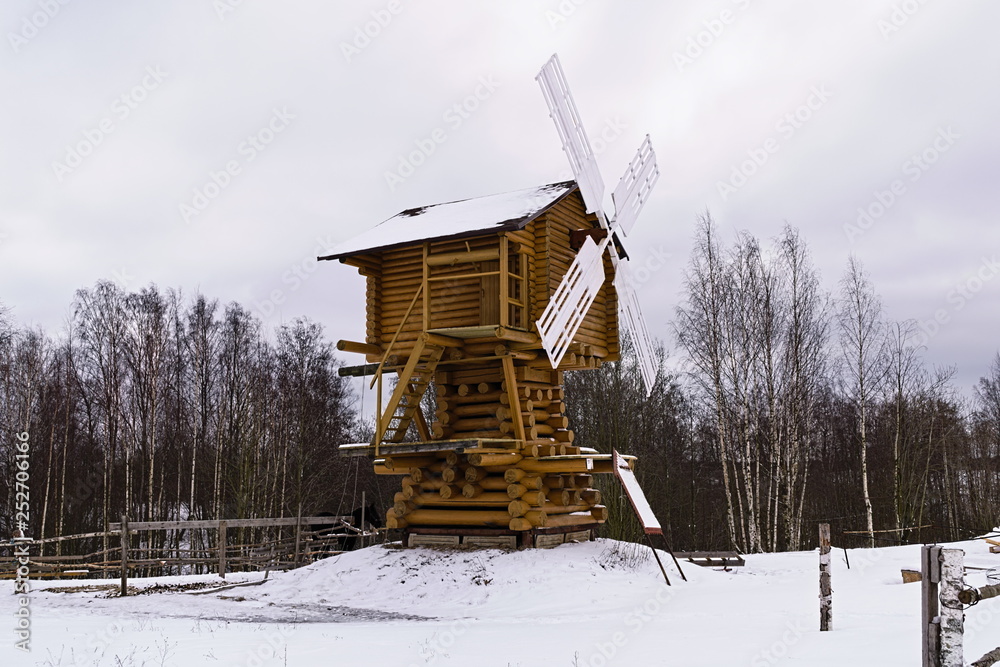 Wooden windmill in the village in the winter Wooden windmill in the village in the winter