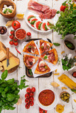 Italian food ingredients on old wooden background, top view.