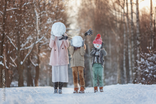 Happy family! Family sculpts snowman in the winter forest. Walking in the winter holidays in nature.