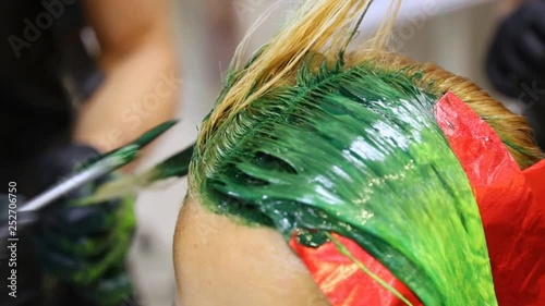 Professional hairdresser dyeing hair. Multicolor with stretching coloring. Fluorescent staining
