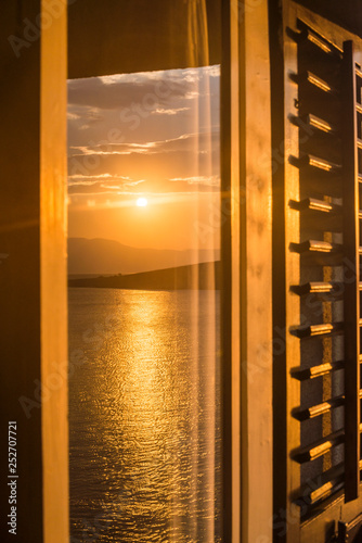 Sunset reflected in house window,  Uvala Scott, Kraljevica, northern Adriatic Sea, Croatia photo