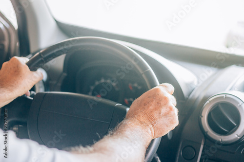Man driving the car with both hands at the wheel. It has spots on the skin. Concept of defensive driving. Travel safely