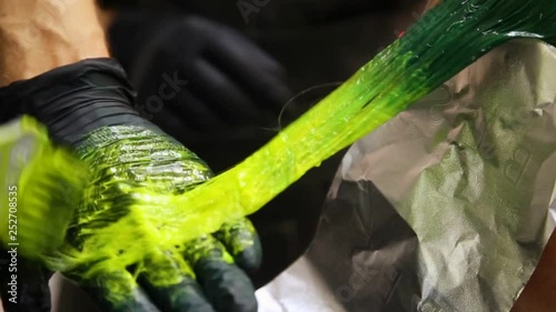 Professional hairdresser dyeing hair. Multicolor with stretching coloring. Fluorescent staining