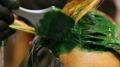 Professional hairdresser dyeing hair. Multicolor with stretching coloring. Fluorescent staining