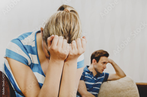 Couple after quarrel. Woman is crying and man takes offense.