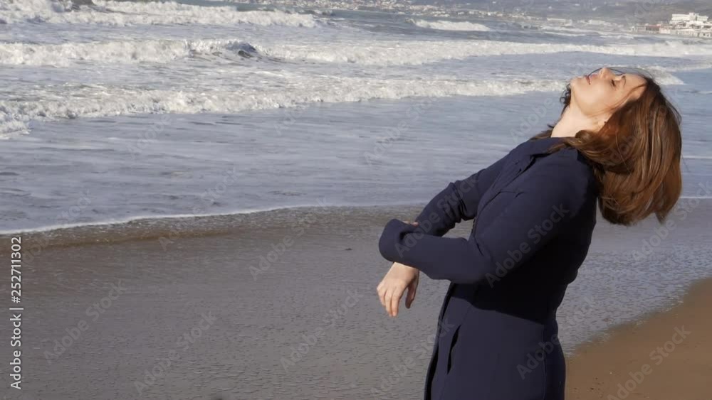 Concept of freedom woman opening arms in front of the ocean slow motion Concept of freedom woman opening arms in front of the ocean slow motion
