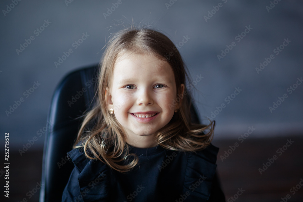 Studio portrait of a girl 4-5 years old on a dark background