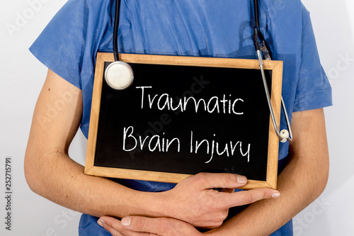 Doctor shows information on blackboard: traumatic brain injury.  Medical concept. photo