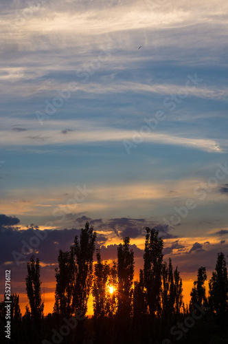 Landscape with dramatic light - beautiful golden sunset with saturated sky and clouds.