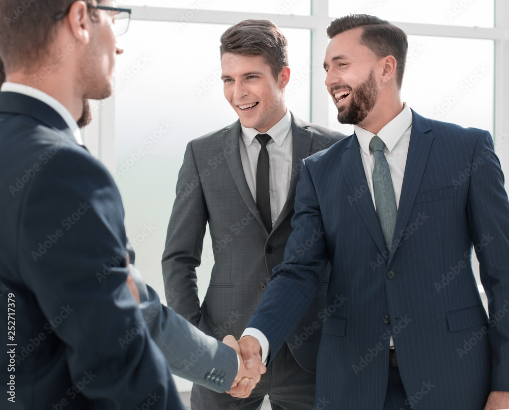 smiling businessman shaking hands with his partner smiling businessman shaking hands with his partner