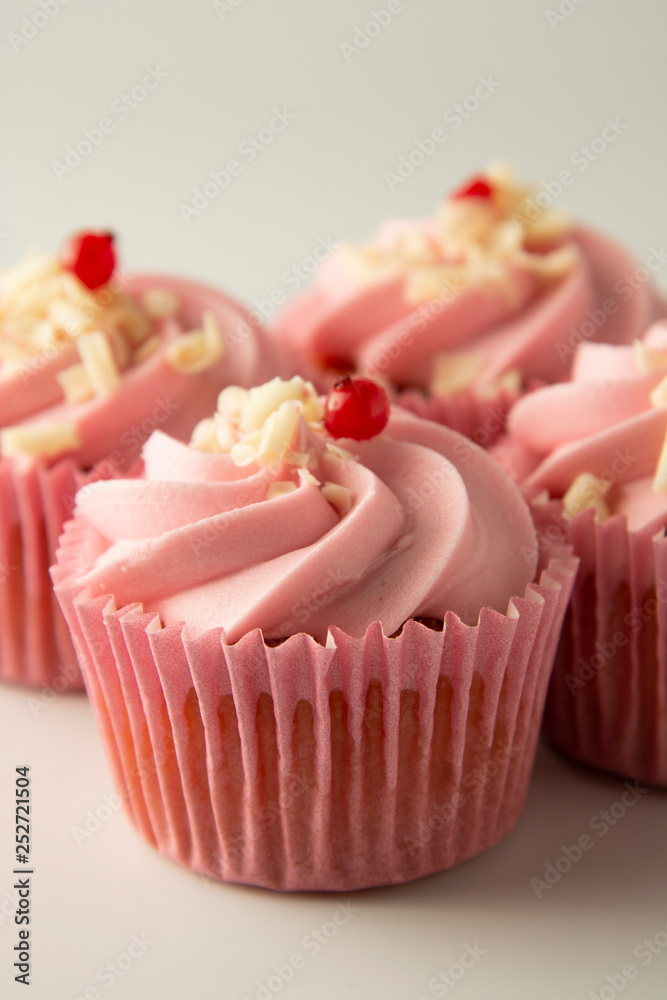 Close up pink, strawbery, fruit cupcakes isoalted. Sweet dessert, shortcakes with cream. Birthday food, cake, muffin. Tempalte for sugar addicted post for social media food content. Vertical image.