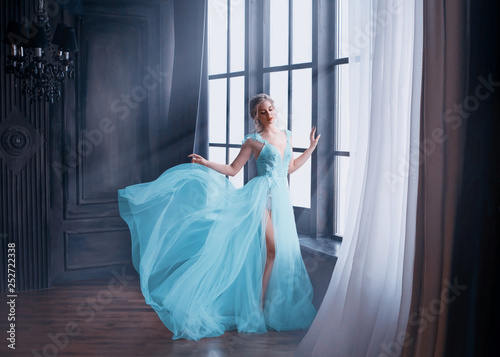 Foto gorgeous image of graduate in 2019, girl in long blue gentle flying dress with bare leg stands alone, fabulous princess