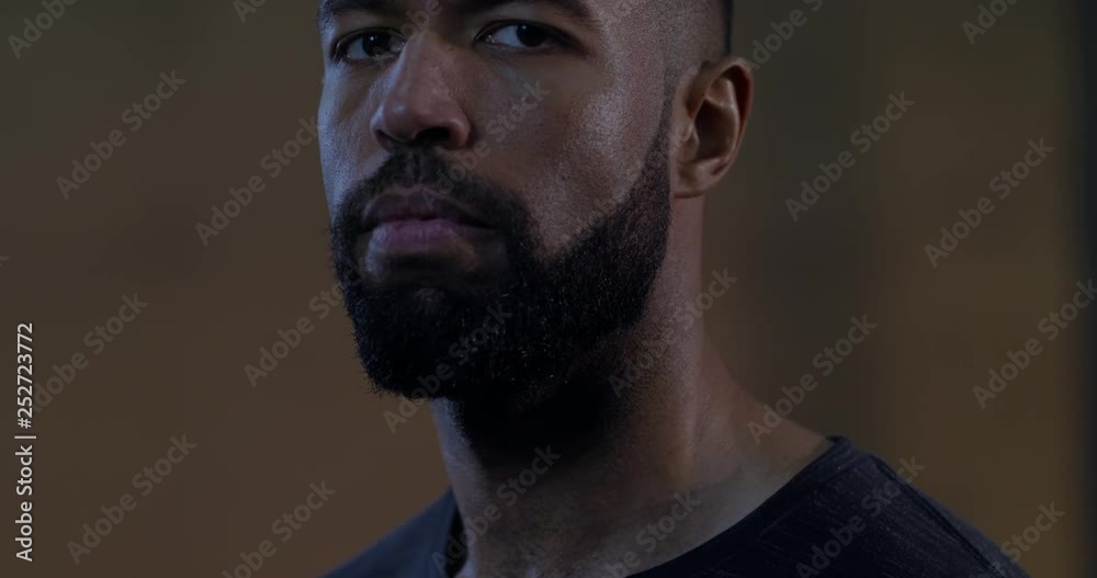 DOLLY IN FOCUS RACK CU portrait of handsome African American black male athlete standing in functional gym, looking into camera. 4K UHD DOLLY IN FOCUS RACK CU portrait of handsome African American black male athlete standing in functional gym, looking into camera. 4K UHD