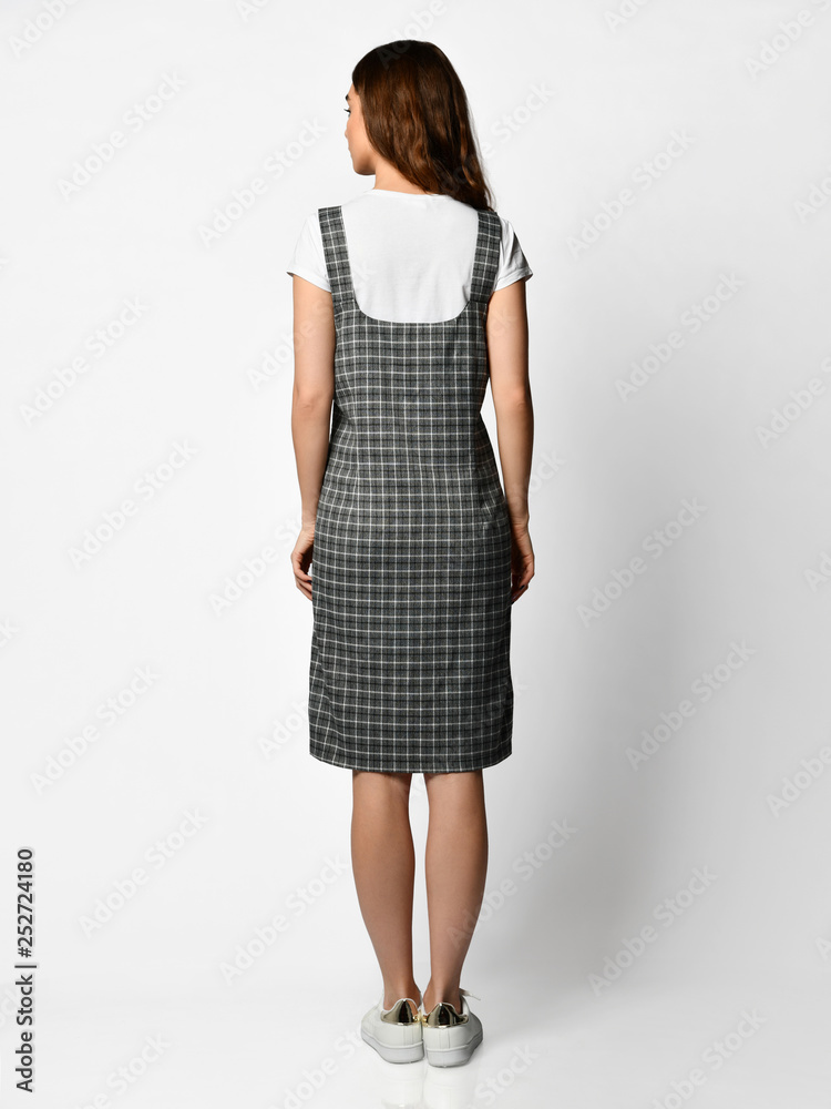 Young beautiful woman posing in new fashion plaid skirt and white blouse full body back side rear view Young beautiful woman posing in new fashion plaid skirt and white blouse full body back side rear view