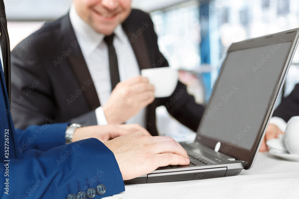 Always in touch. Cropped closeup of a businessman using his laptop in a restaurant Always in touch. Cropped closeup of a businessman using his laptop in a restaurant