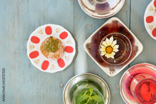 Obraz na płótnie traditional Turkish red black tea tulip glass green flowers sweet dessert afternoon tea break w salonie