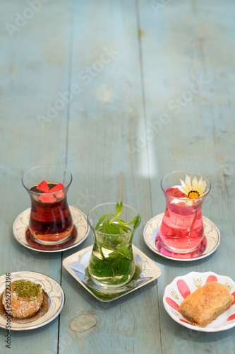 Obraz na płótnie traditional Turkish red black tea tulip glass green flowers sweet dessert afternoon tea break w salonie