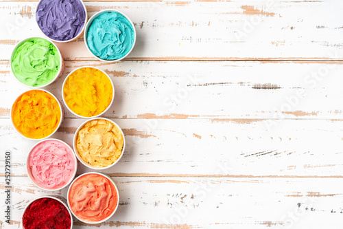 Top view of colorful rainbow ice cream in cups. Copy space
