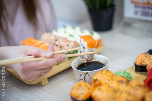 girl eating sushi set with chopsticks on restaurant