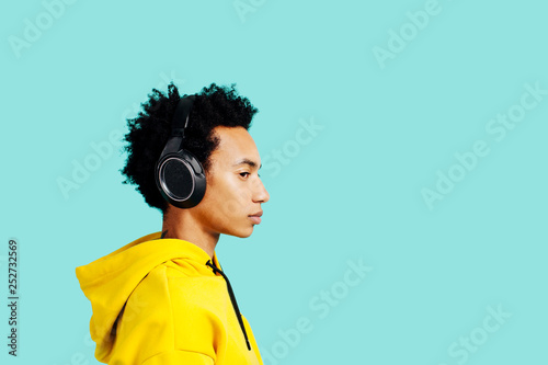 Profile portrait of a young man with headphones listening to music 