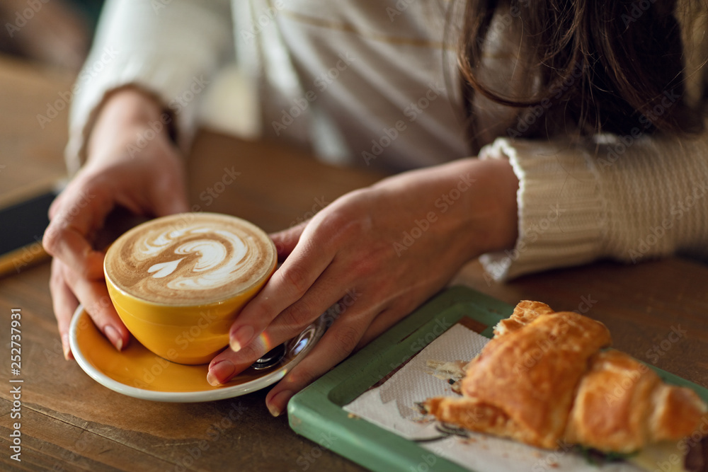 Close up of woman holding cup of coffee during breakfast time. Close up of woman holding cup of coffee during breakfast time.