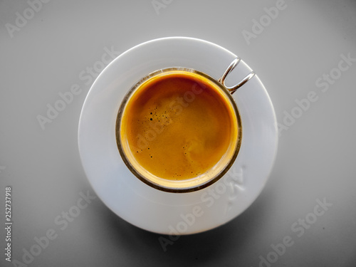 Taza de caf   solo con plato blanco y taza de cristal en vista cenital.