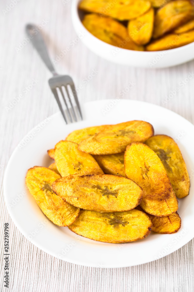 Fried slices of ripe plantains traditional snack and accompaniment in Central America and Northern South America (Selective Focus, Focus one third into the image) Fried slices of ripe plantains traditional snack and accompaniment in Central America and Northern South America (Selective Focus, Focus one third into the image)