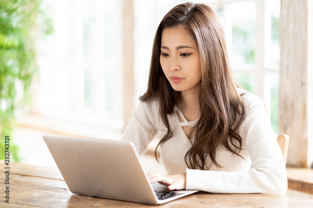 attractive asian woman using laptop in living room attractive asian woman using laptop in living room