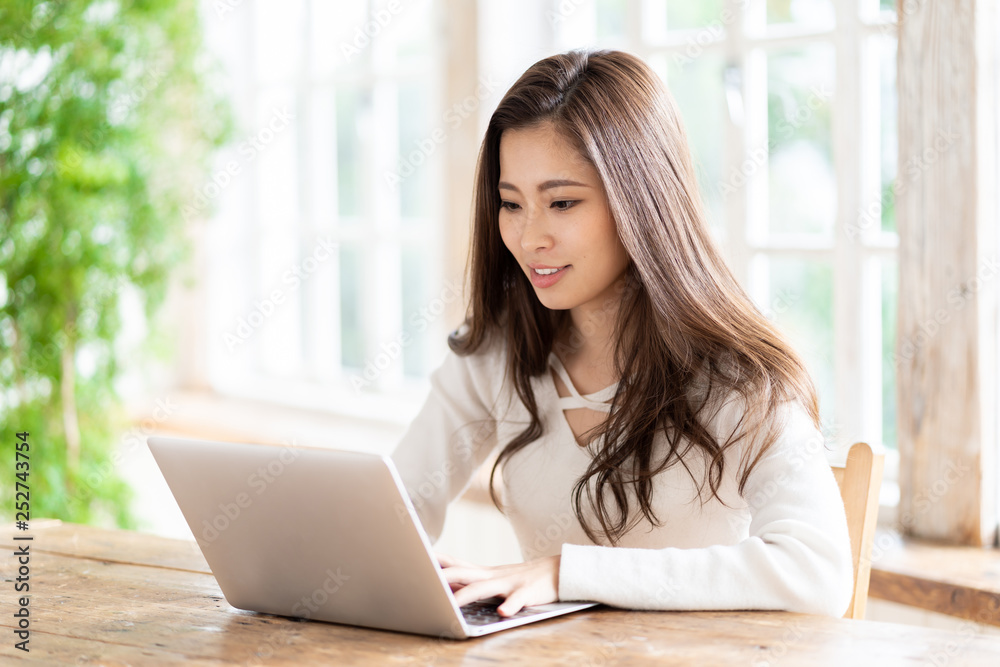 attractive asian woman using laptop in living room attractive asian woman using laptop in living room