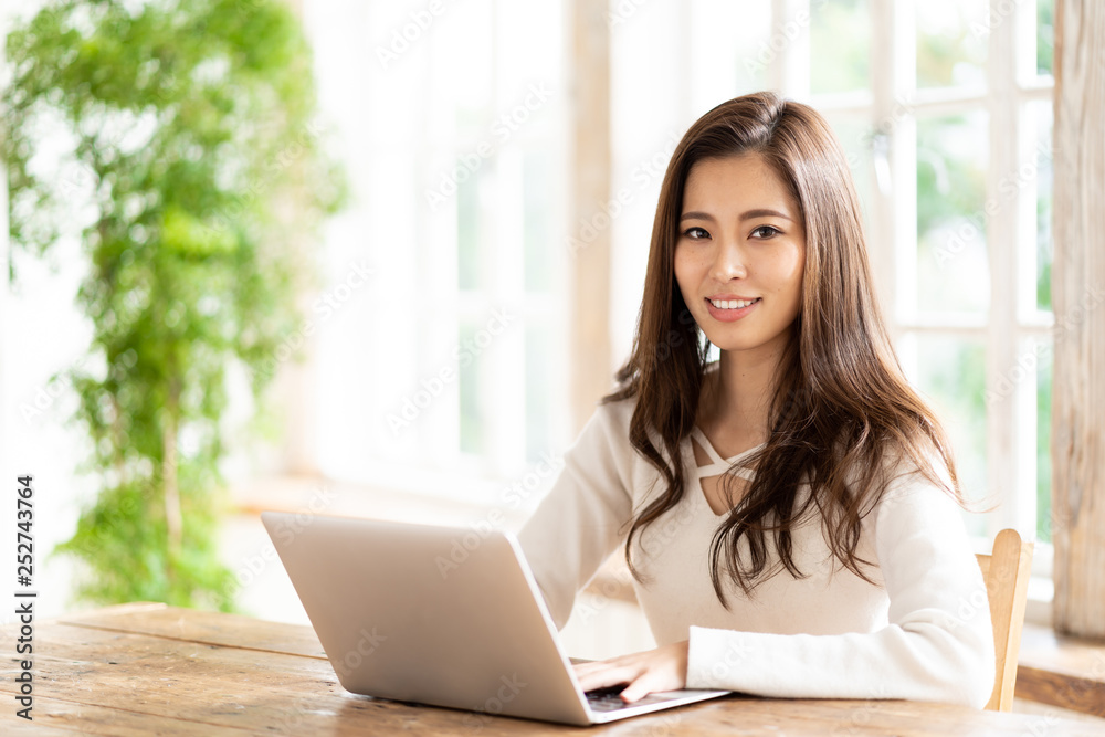 attractive asian woman using laptop in living room attractive asian woman using laptop in living room