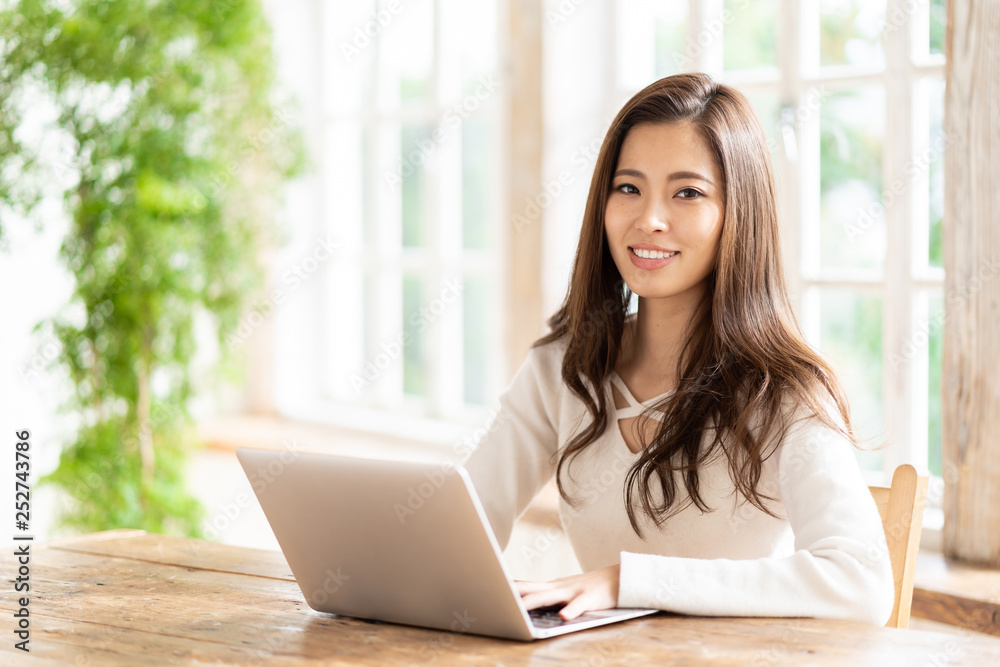 attractive asian woman using laptop in living room attractive asian woman using laptop in living room