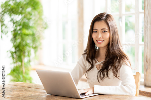 attractive asian woman using laptop in living room