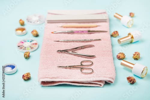 Manicure tools on a pink towel and a blue background. Manicure background.