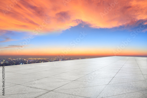 Empty square floor and modern city skyline with beautiful colorful clouds at sunset © ABCDstock