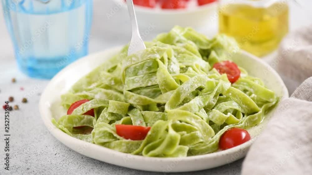 Tasting vegetarian green spinach pasta with cherry tomatoes and olive oil. HD footage Tasting vegetarian green spinach pasta with cherry tomatoes and olive oil. HD footage
