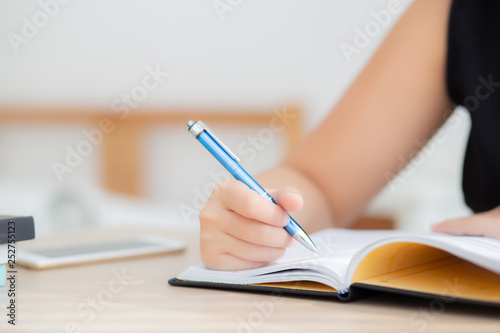 Closeup hand asian woman sitting study and learning writing notebook and diary on table in living room at home, girl homework, business writer woman working on table, education concept.