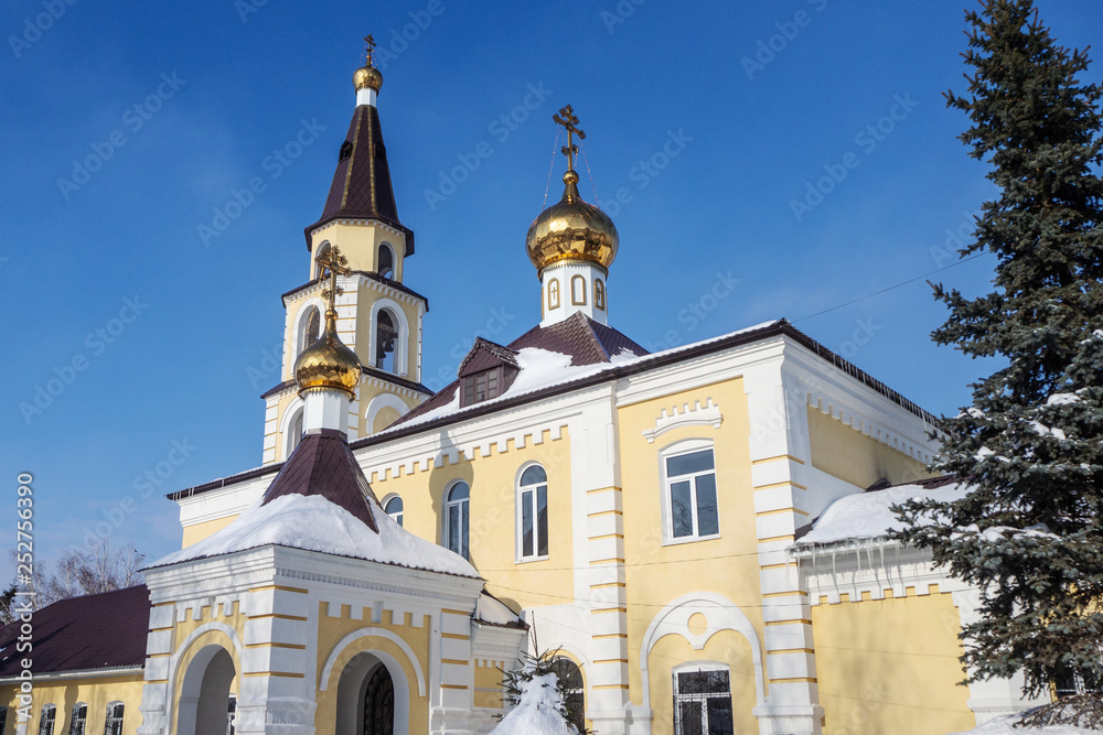 Orthodox temple with gold crosses and domes against the blue sky. Winter.