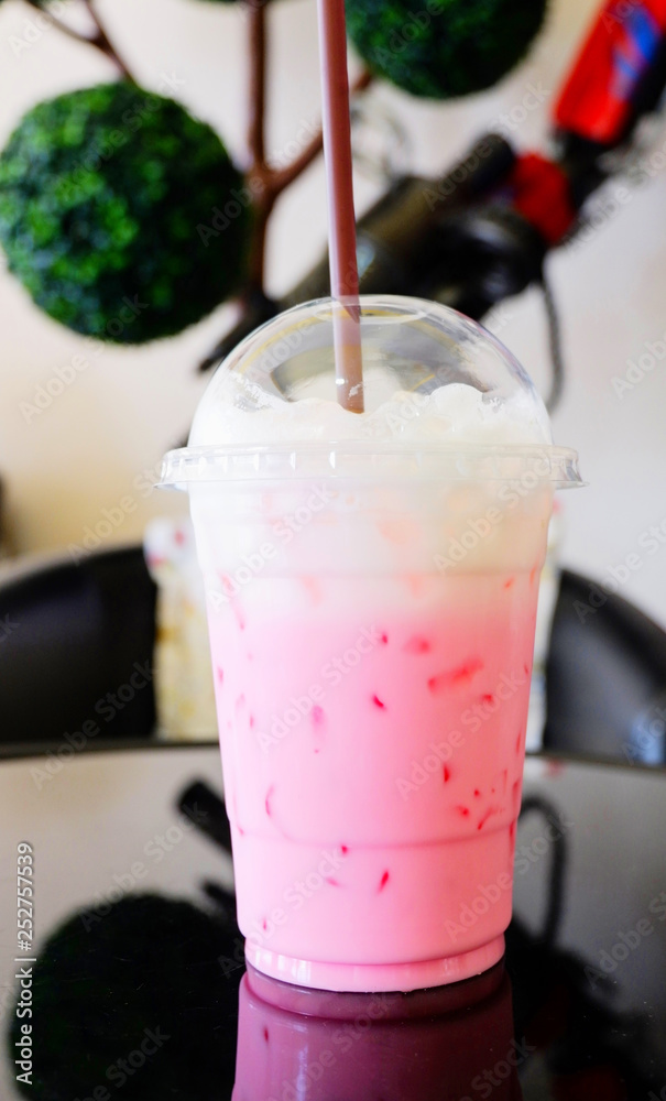 Strawberry milk pink shake / Iced pink fresh milk in plastic cup and straw  on table coffee shop Photos | Adobe Stock